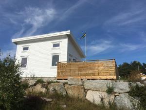 a white house with a flag on top of a wall at Guest Haush Ånneröd in Strömstad