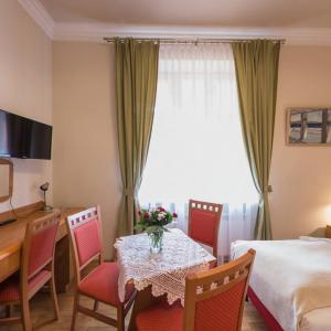 a hotel room with a table and chairs and a bed at Apartamenty Kajzer in Krakow