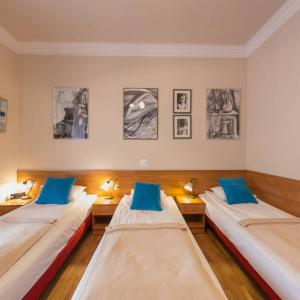 two beds in a room with paintings on the wall at Apartamenty Kajzer in Krakow