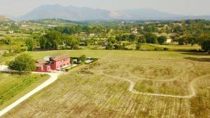 an aerial view of a field with a red house at B&B Colle Cucchiara in Cassino