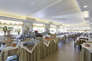 a banquet hall with white tables and chairs at Hotel Piccadilly in Lido di Camaiore
