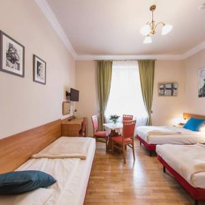 a hotel room with two beds and a table at Apartamenty Kajzer in Krakow