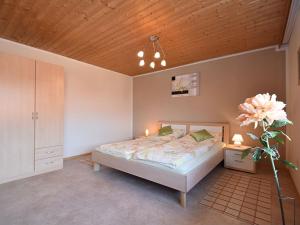 a bedroom with a bed and a wooden ceiling at Charming holiday flat in the Bavarian Forest in Gleißenberg