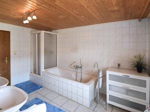 a bathroom with a tub and a sink at Charming holiday flat in the Bavarian Forest in Gleißenberg
