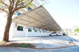 a parking lot with a white car parked under awning at Fang Villa Hotel in Fang