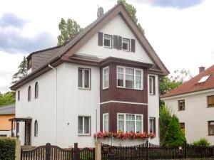a white and brown house with a black fence at Ferienwohnung Baade in Dresden