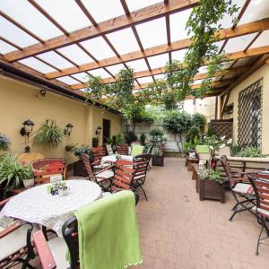 a patio with tables and chairs and a glass roof at Apartamenty Kajzer in Krakow