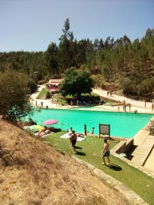 a group of people standing around a swimming pool at Casas da Encosta in Proença-a-Nova