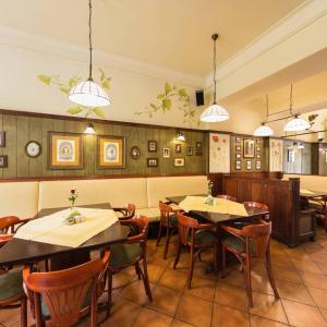 a dining room with tables and chairs and pendant lights at Apartamenty Kajzer in Kraków
