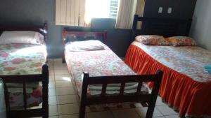 a room with two twin beds and a window at Hotel San Marino in Goianésia