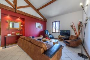 Gîte Le Planier في سانت-بريست: غرفة معيشة مع أثاث بني وجدران حمراء
