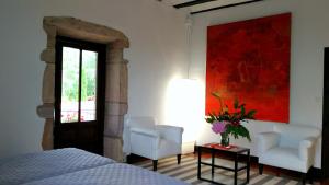 
a room with a bed and a painting on the wall at Hostal Palacio Jaureguia in Irurita
