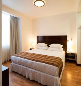 Habitación de hotel con cama grande y ventana en Hotel Casa Beltran, en Arica