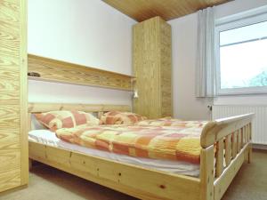 ein Schlafzimmer mit einem Holzbett und einem Fenster in der Unterkunft Snug Apartment in St Andreasberg in Harz in Sankt Andreasberg