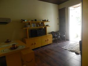 uma sala de estar com uma televisão e uma mesa e cadeiras em Apartamento Edificio Mirage em Salvador