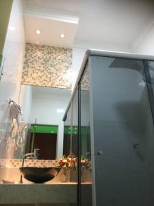 Impérium Inn Motel (Adult Only) في Nova Ponte: حمام مع حوض ومرآة
