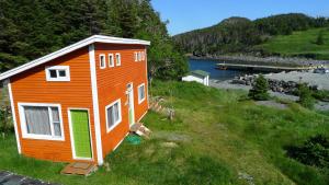 una pequeña casa al lado de una colina en East Coast Newfoundland Cottage & Cabins en Bauline East