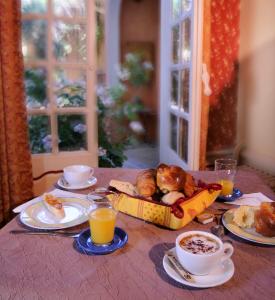 a table with a breakfast of food and orange juice at Hôtel du Fiacre in Carpentras