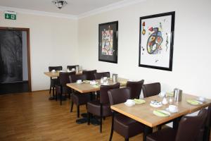 a dining room with wooden tables and chairs at Hotel Schwarzer Adler in Moers