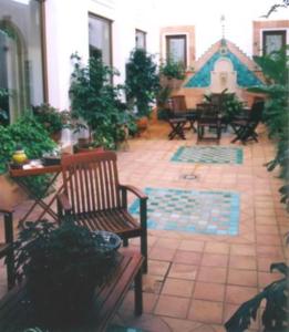 um pátio com bancos, uma mesa e uma tenda em Plaza Chica em Cartaya