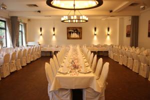 une salle de banquet avec des tables blanches et des chaises blanches dans l'établissement Hotel Schwarzer Adler, à Moers