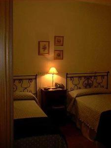 a bedroom with two beds and a lamp on a table at Plaza Chica in Cartaya