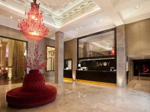 eine Lobby mit einem Kronleuchter und einer Vase mit Blumen darin in der Unterkunft Savoy Hotel in Buenos Aires