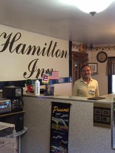 a man standing behind a counter in a restaurant at Hamilton Inn Sturbridge in Sturbridge
