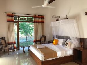 a bedroom with a bed and a large window at Aki Villa in Pasikuda