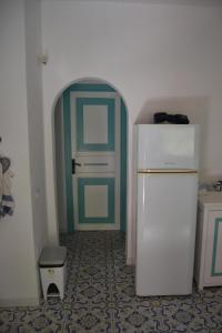 ヴルカーノにあるVilla Buganvilleeの緑のドア付きの客室内の白い冷蔵庫