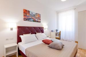 a bedroom with a large bed with a red headboard at Dolce Luxury Rooms in Rome