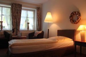 a hotel room with a bed and a lamp and window at Bärenkrug in Molfsee