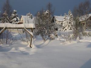 a snow covered yard with houses and trees at Ferienwohnung Meyer in Schönwald