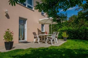 a patio with a table and chairs and an umbrella at Ferienwohnung Meyer in Schönwald