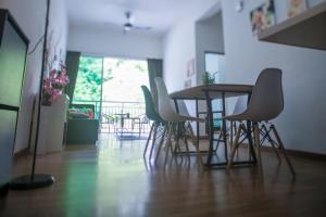 een tafel en stoelen in een kamer met een balkon bij Strawberry Homestay in Cameron Highlands
