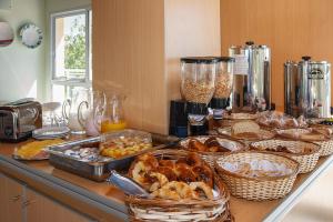 un mostrador con muchos platos de comida en una mesa en Hosteria Chaltu, en Villa Gesell