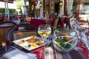 a table with a plate of food and wine glasses at Auberge de la Terrasse in Villersexel +38 photos
