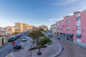 una calle de la ciudad con coches y edificios aparcados en Best Houses Portugal Residence, en Peniche