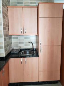 a kitchen with wooden cabinets and a sink at Apartamento en el centro de Nerja in Nerja