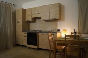 a kitchen with wooden cabinets and a wooden table with a tableablish at Sa Tanca de Mannoi in Orosei