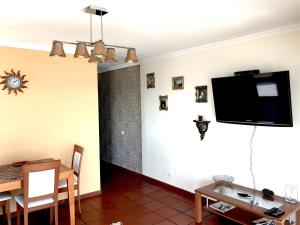 a living room with a flat screen tv on a wall at Apartamento Romantico by the Ocean in Caniço