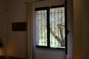 a window with a view of a tree at Sa Tanca de Mannoi in Orosei