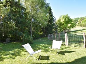 沃德呂尼的住宿－布爾功德度假屋，两把白色椅子坐在院子里的草地上