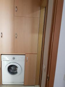 a washing machine in a kitchen with wooden cabinets at Apartamento en el centro de Nerja in Nerja