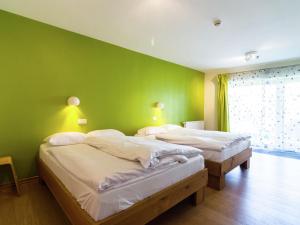 2 Betten in einem Zimmer mit grüner Wand in der Unterkunft Luxurious Cottage in Sourbrodt with Sauna in Weismes
