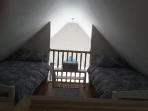 a attic room with two beds and a window at Island View Lodge in Doolin