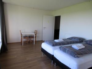 a room with two beds and a table and a table and chairs at Rauðaberg II in Raudaberg