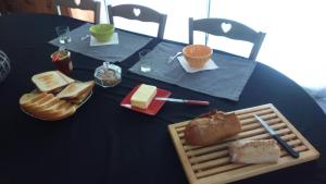 a blue table with a plate of bread and cheese at Maison ecologique en paille in La Chapelle-Enchérie