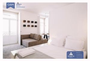 sala de estar con cama y silla en ORM - Almada Apartments, en Oporto