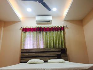 a bedroom with a bed with a curtain and a air conditioner at Mega Tourist Home Palarivattom in Cochin